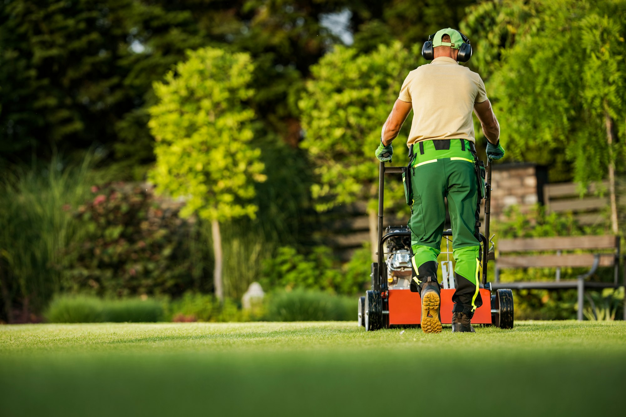 Landscaper Pushing Scarifier Machine Taking Care of the Lawn